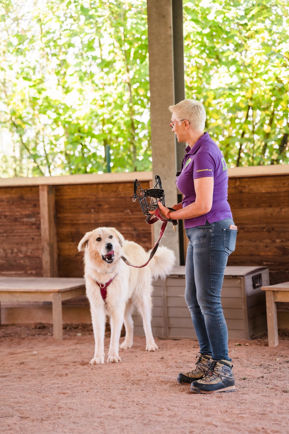 Mirjam Cordt steht ruhig neben einem großen Herdenschutzhund